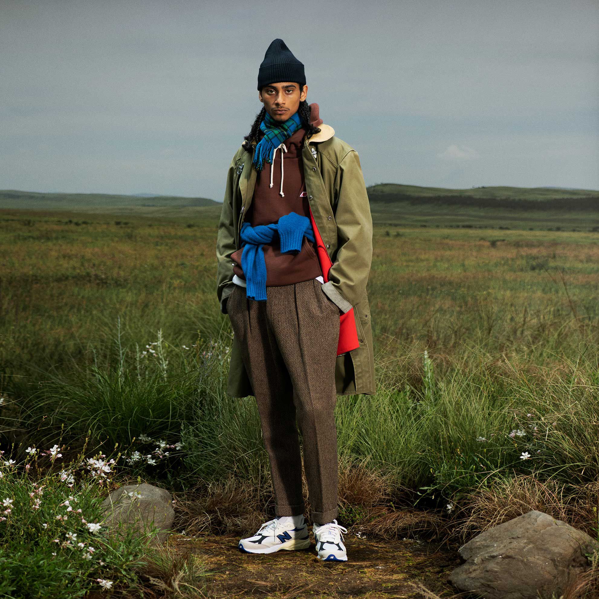 Painter wearing a paid of MADE in US sneakers standing in a concrete studio environment using a roller to paint the backdrop.