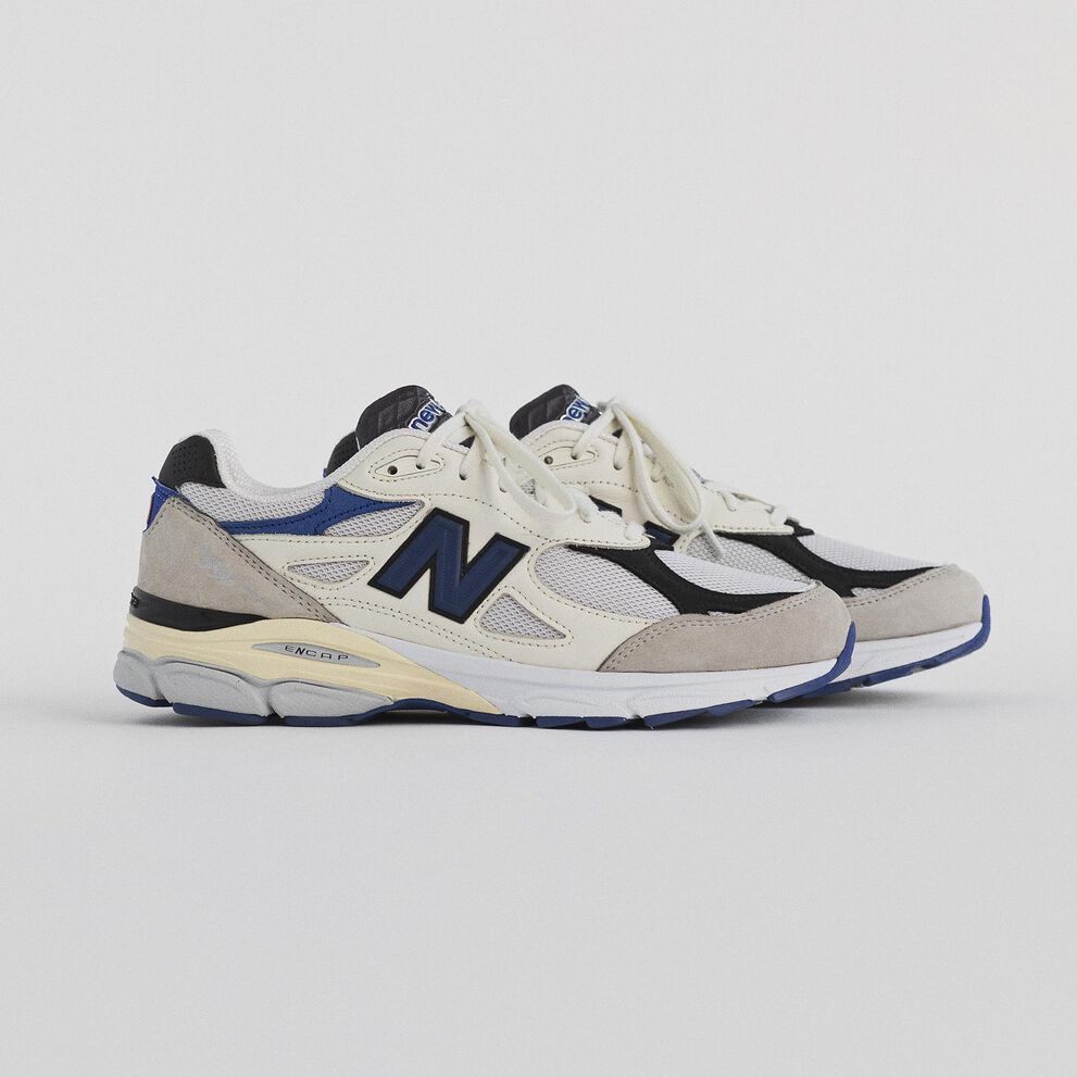 Pair of white 990v3 from the upcoming Made in USA Collection on a grey studio backdrop.