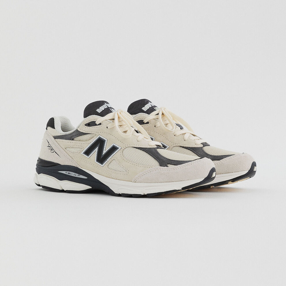 Pair of white 990v3 from the upcoming Made in USA Collection on a grey studio backdrop.